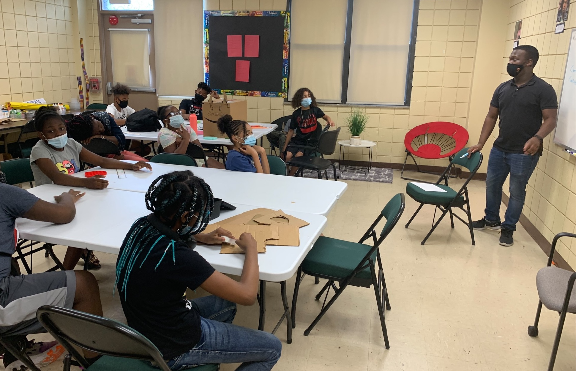 Five young Black girls in Ellis School uniforms stand in a row smiling